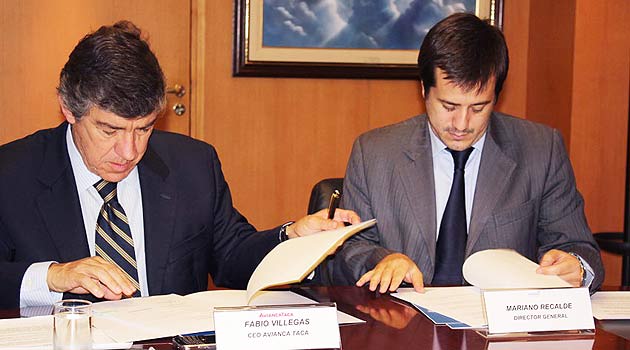 O CEO da AviancaTaca, Fabio Villegas, e o diretor geral da Aerolíneas Argentinas, Mariano Recalde, assinam o acordo em Buenos Aires (foto divulgação)